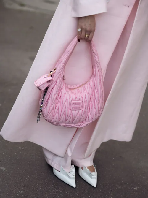 Nina Sandbech is seen wearing a white turtleneck, pale pink pants and matching coat, white Prada shoes, candy pink Miu Miu bag and Miu Miu sunglasses during the Womenswear Fall/Winter 2024/2025 as part of Paris Fashion Week on March 04, 2024 in Paris, France.