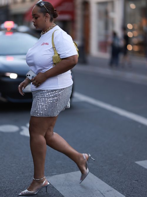 Fashion Show Guest is seen wearing miu miu shades, golden jewelry, a white tshirt with the logo of jean paul gautier, a shiny silver skirt, silver shoes and s green and yellow bag outside during the Ludovic de Saint-Sernin Menswear Spring/Summer 2024 as part of Paris Fashion Week on June 25, 2023 in Paris, France.