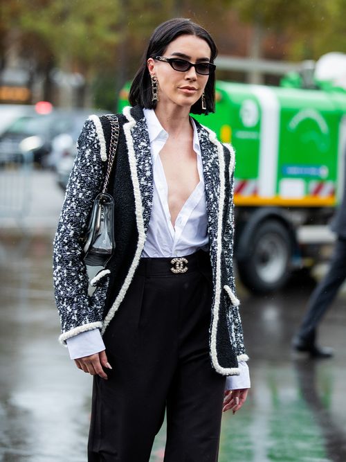Streetstyle mit einer weißen Bluse, einer schwarzen Hose und einer Boucléjacke.