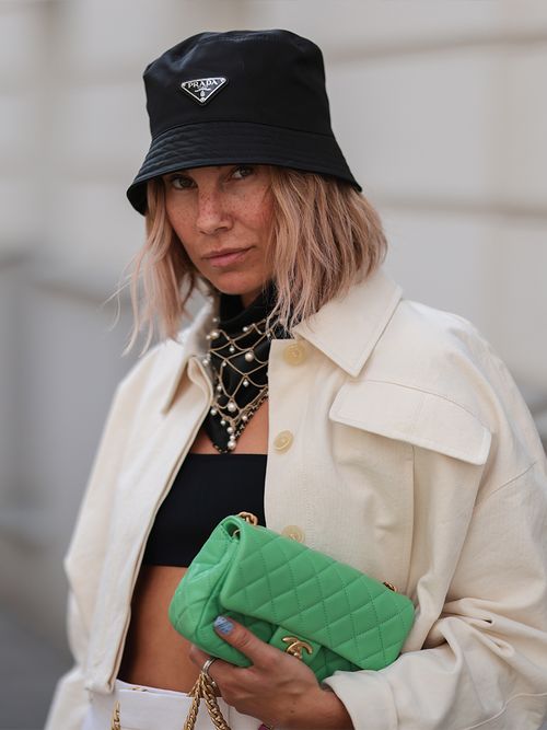 Karin Teigl mit einem schwarzen Bucket Hat von Prada und einer grünen Chanel Bag.