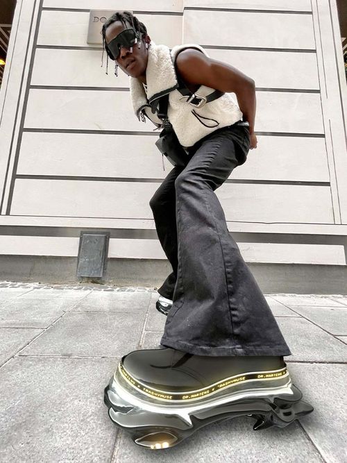 Futuristix mit einer weißen Weste, einer Schlaghose und digitalen Dr. Martens.