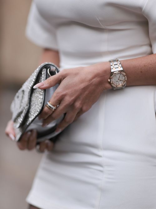 A guest wears a white dress and a silver watch