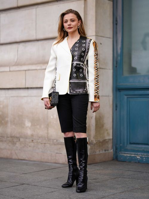 Chloe Grace Moretz wears biker shorts with a blzaer and knee high boots