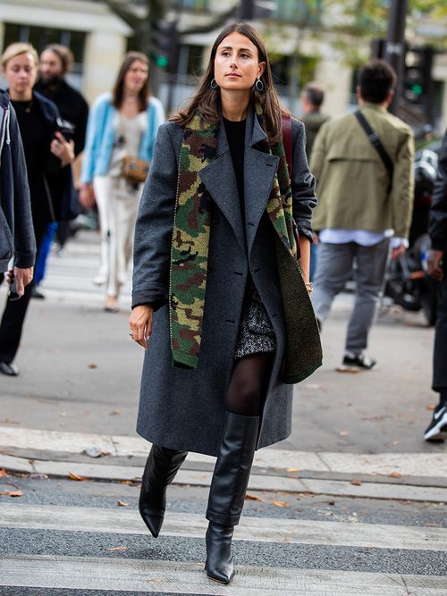 Streetstyle mit einem grauen Mantel, schwarzen Stiefeln und einem grünen Schal.