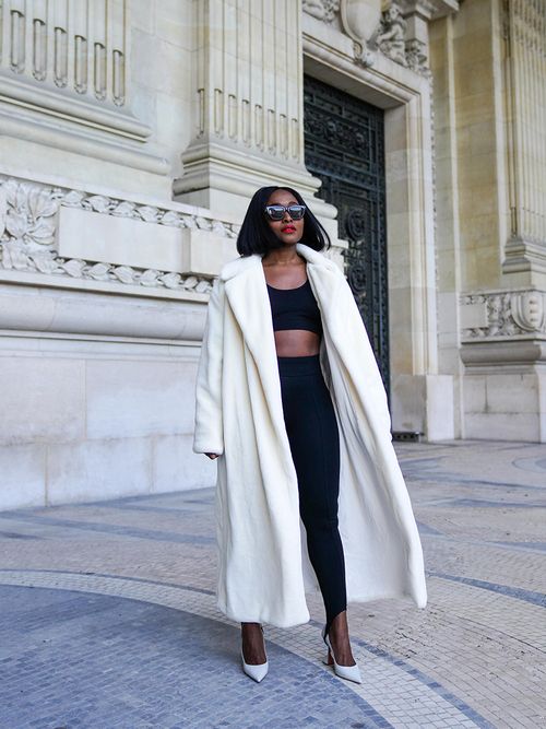 Streetstyle mit einer schwarzen Leggings und einem cropped Top zu einem weißen langen Mantel.