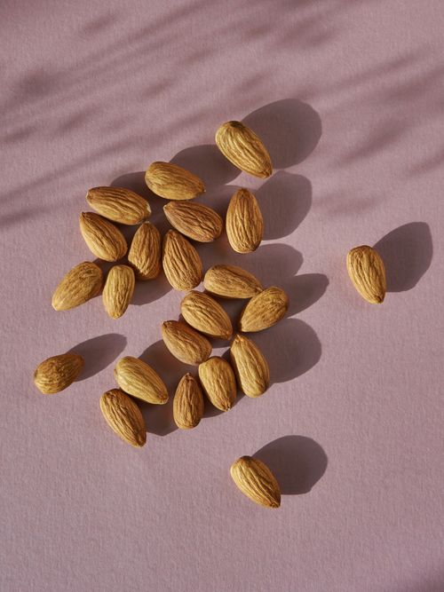 Mandeln die auf einem lila Untergrund liegen.
