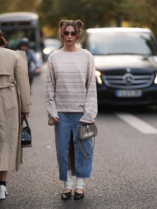 Guest wears a long denim skirt with beige sweater and socks