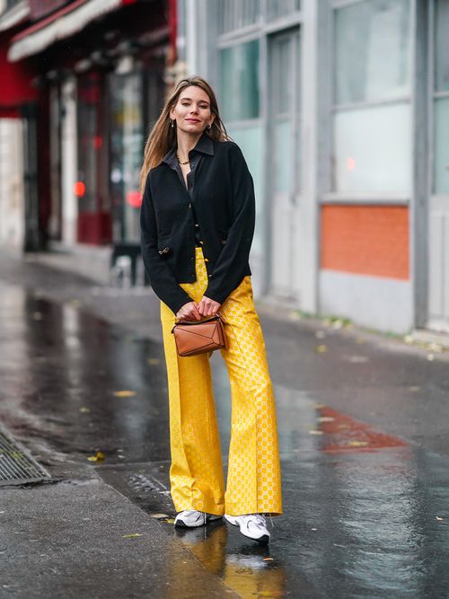 Streetstye mit einer dunkeln Jacke, einer gelben Hose und Sneakers.