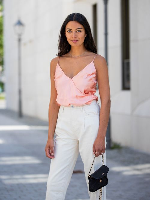 Streetstyle mit einer weißen Jeans und einem roséfarbenen Lingerietop.