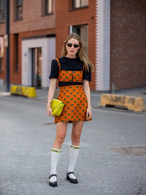 Anabell Rosendahl in einem orangenen Rock zu kniehohen Strümpfen und Mary Janes.