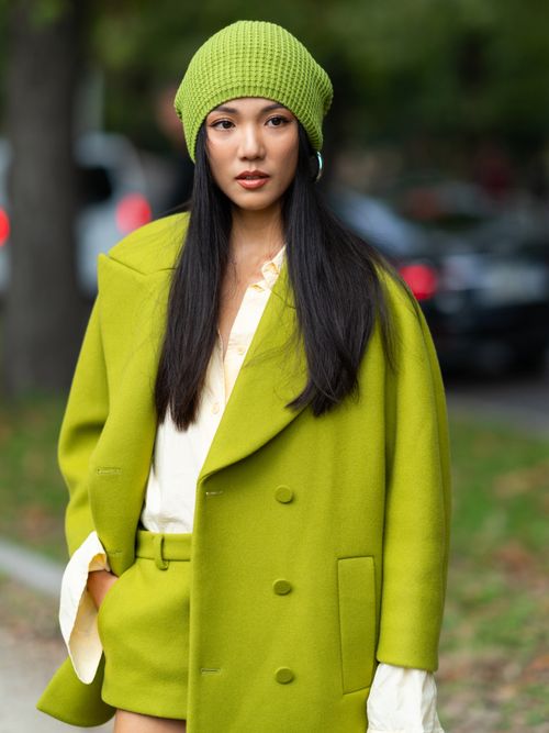 Yoyo Cao trägt ein Limettengrünes Ensemble mit weißer Bluse und Mütze auf der Milan Fashion Week.