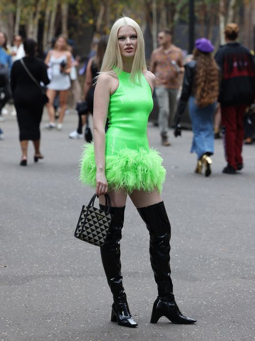 Guest wearing green dress, knee high boots David Koma at Tate Modern during London Fashion Week September 2023 on September 16, 2023 in London, England.