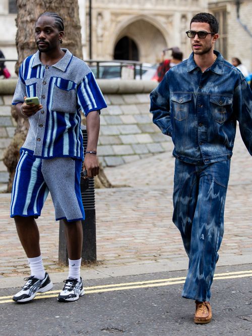 Street Style Look von der London Fashion Week, wo zwei Männer blaue Outfits tragen.