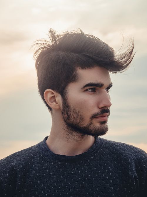 Mann mit Bart und extravaganter Frisur