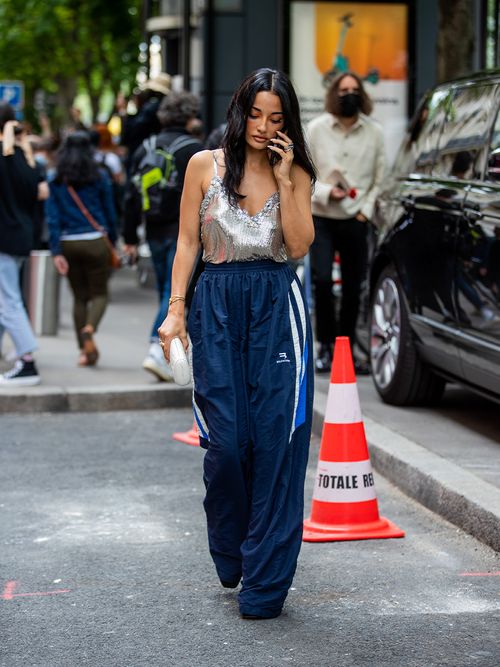 Streetstyle mit einem silbernen Glitzertop und einer blauen Trackpants.