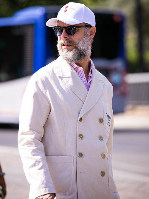 Streetstyle mit einem weißen zweirreihigen Sakko und einem weißen Baseball Cap.
