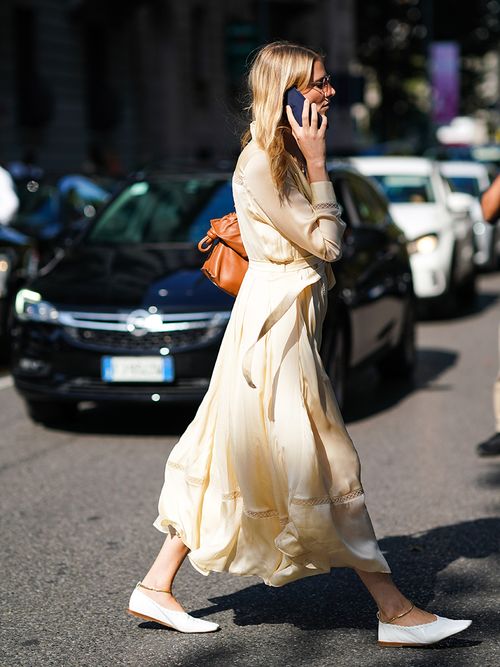 Ein Streetstyle-Look mit einem gelben langärmigen Kleid und weißen Ballerinas.