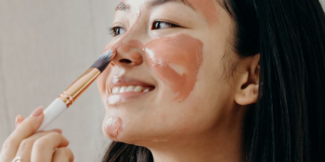 Eine Frau die sich gerade eine Gesichtsmaske aufträgt