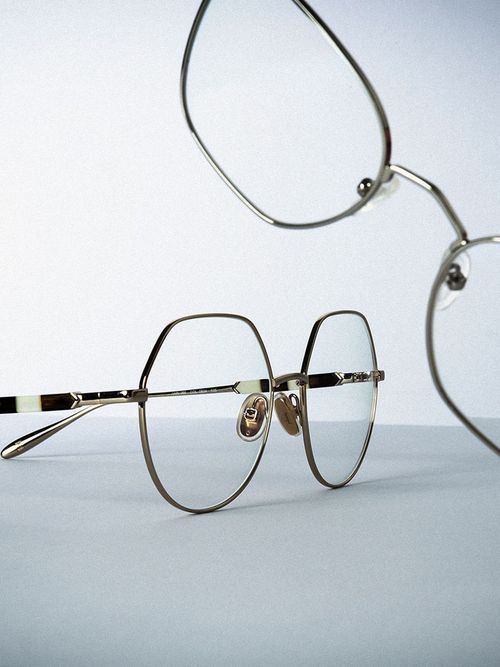 Close up von zwei zarten goldenen Brillenfassungen.