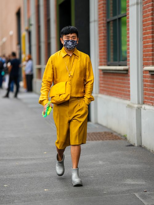 Mann trägt eine lockere Bermudashorts mit Bügelfalte auf der Milan Fashion Week