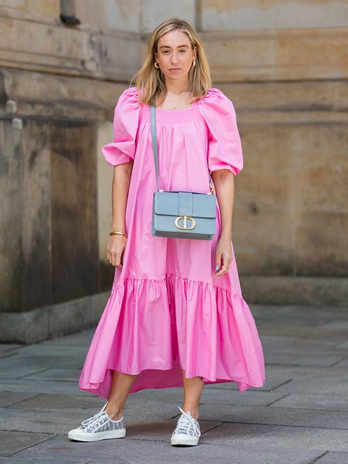 Sonia Lyson in einem pinken Kleid und Sneakers von Dior in Berlin.