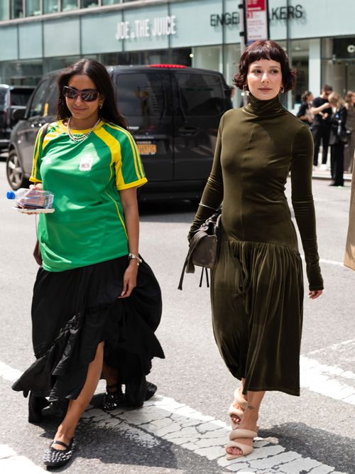 NYFW guests wear wraparound sunglasses, a green and yellow football jersey, a black tiered maxi skirt, and studded black leather Mary Janes (left); an olive green high neck midi dress, gold jewellery, an olive green leather handbag, and tan heels (right).