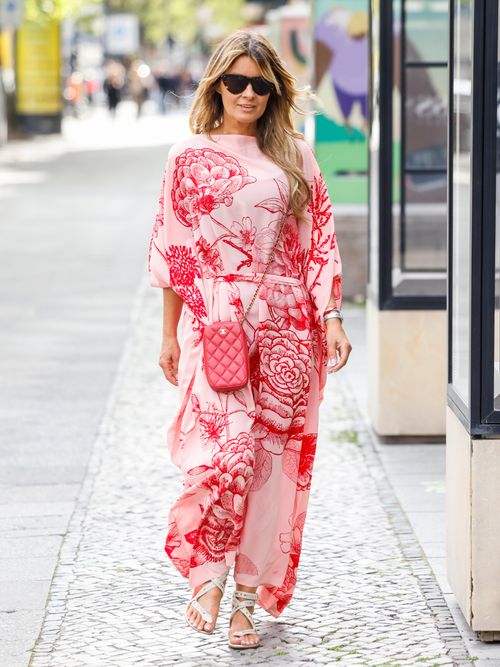 Influencer Gitta Banko, wearing a red-white silk kaftan dress by Simone Bruns, a red bag by Chanel. sandals by Dior and sunglasses by Bottega Veneta, during a streetstyle shooting on May 14, 2023 in Berlin, Germany.