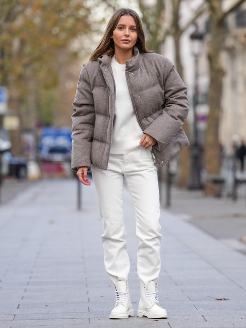 Streetstyle mit einer weißen Hose und Pullover zu einer beigen Pufferjacke.
