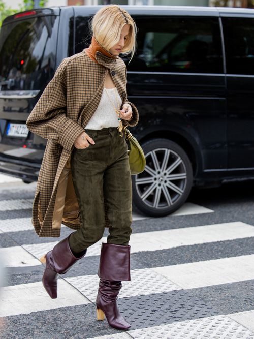 A guest wears brown checkered coat, green velvet pants, burgundy boots, green bag outside Chloe during Womenswear Spring/Summer 2025 as part of Paris Fashion Week on September 26, 2024 in Paris, France.