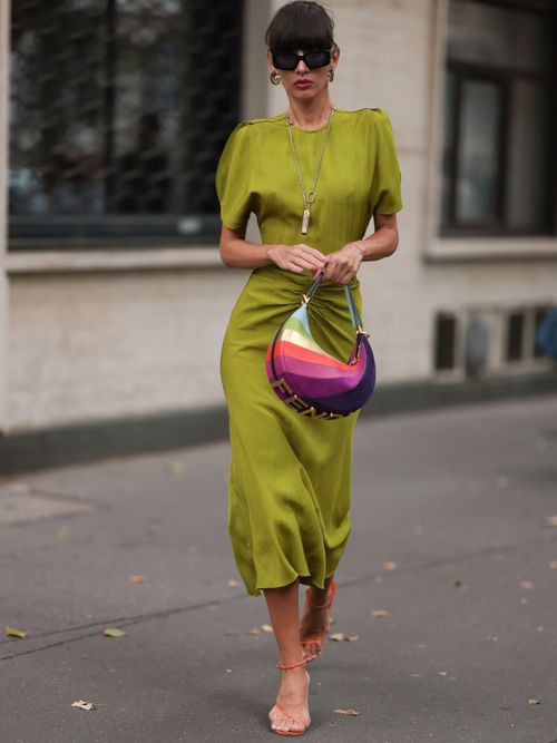 Katya Tolstova trägt ein Moosgrünes Kleid mit bunter Fendi-Tasche und orangefarbenen Sandaletten auf der Paris Fashion Week.