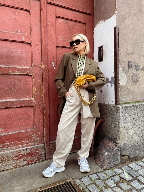 Streetstyle mit einem gestreiften Anzug und einer Bottega Veneta Tasche.