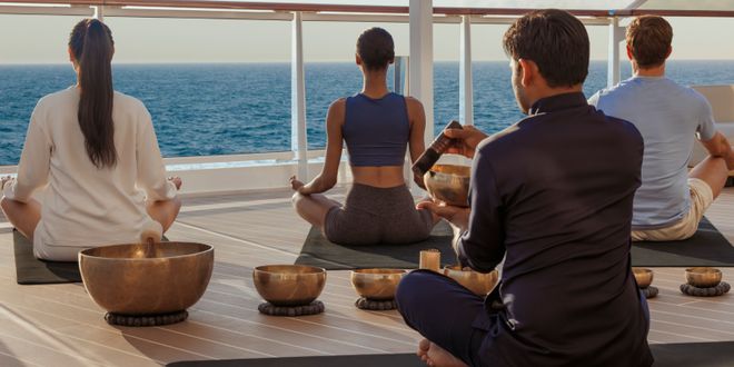 A group of people doing yoga on a cruise ship deck.
