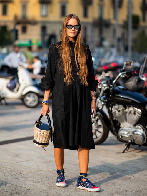 Carlotta Oddi trägt ein schwarzes Midikleid mit schwarzen Accessoires und einer Korb-Beuteltasche.