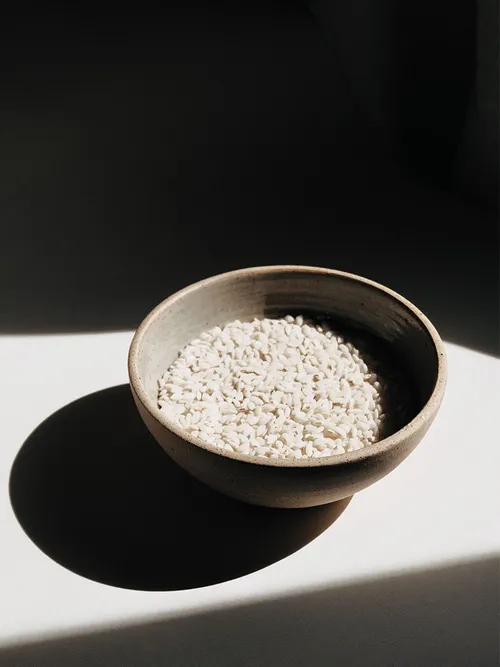 Eine beige Schale mit trockenem Reis.