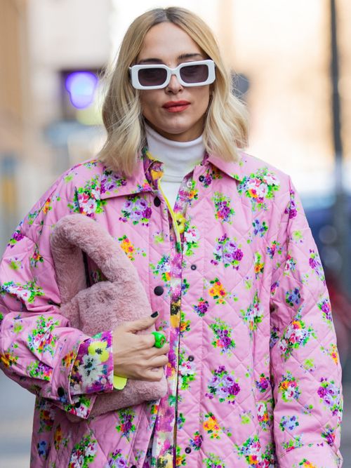Streetstyle mit einer geblümten Steppweste in rosa und einer Tasche aus Fell.