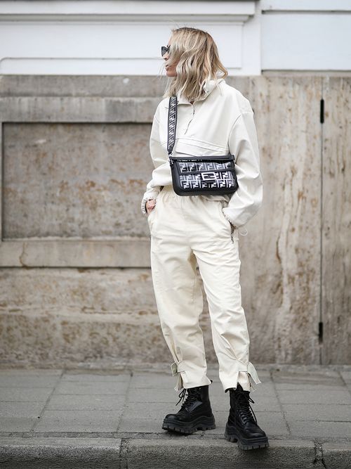 Streetstyle mit einem Totallook in Weiß zu schwarzen Springerstiefeln und einer Fendi-Tasche mit Logoprint.