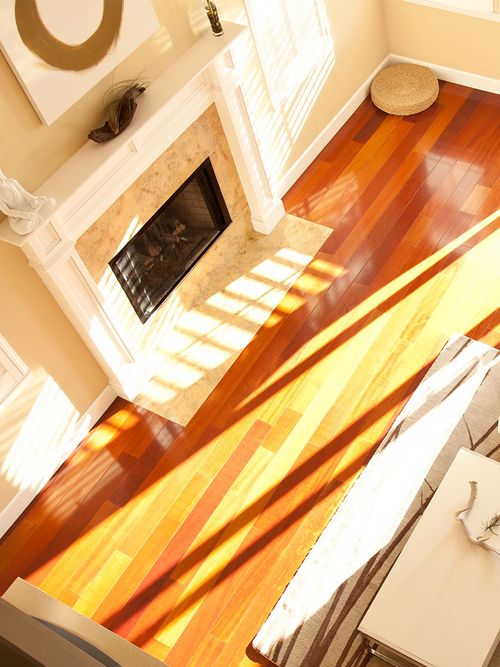 Wohnzimmeransicht von oben auf einen Holzboden und einen weißen Kamin auf dem ein Buddha steht.