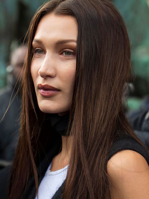 Bella Hadid mit geglätteten langen Haaren und einem Mittelscheitel.