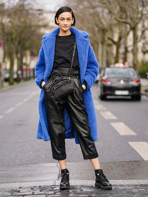 A guest wears a blue coat and black leather trousers