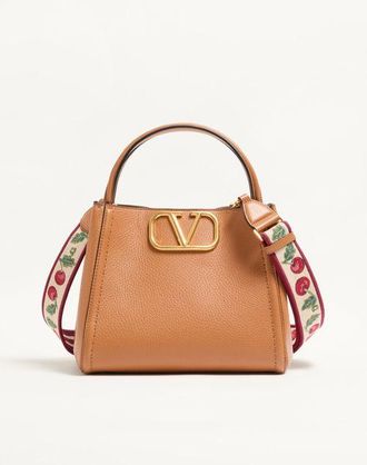 Valentino Garavani Valentino Garavani Alltime medium handbag in grainy calfskin with Cherryfic embroidered ribbon shoulder strap. Wo