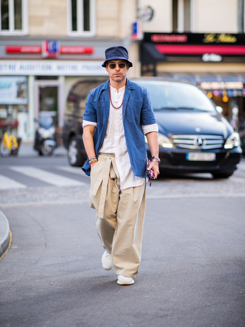 Alex Badia trägt ein kurzes Jeanshemd mit weißem Hemd darunter und eine beige weite Hose auf der Paris Fashion Week.