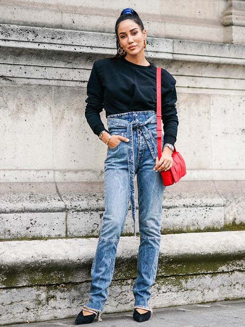 Streetstyle mit High-Waist-Jeans und einem schwarzen Sweater.