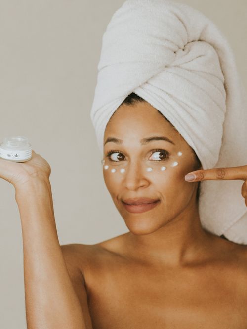 Frau trägt gerade Augencreme auf