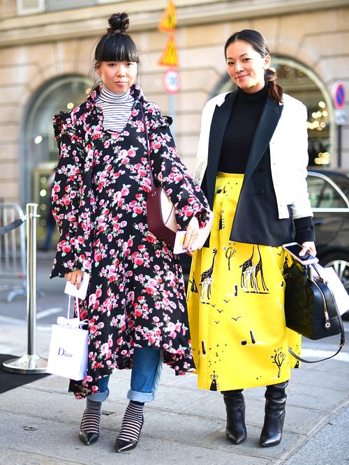 Suzy Bubble wearing a a dark floral dress over jeans and a turtleneck.