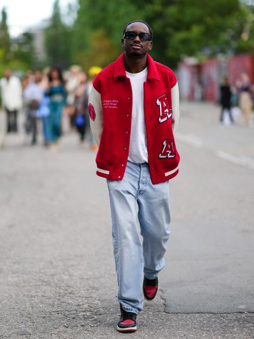Street Style Look von einem Gast auf der Copenhagen Fashion Week der eine angesagte Übergangsjacke im College Style trägt