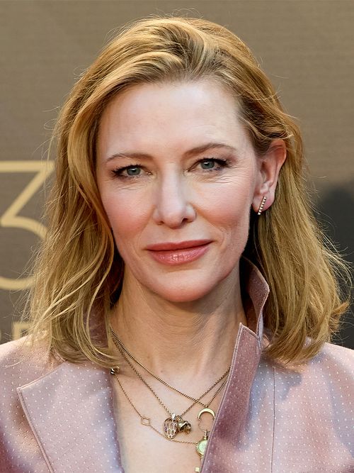 Cate Blanchett in einem rosa Blazer mit vielen goldenen Ketten.