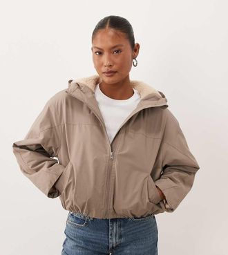 Asos Petite ASOS DESIGN Petite giacca impermeabile corta con cappuccio e fodera in pile borg in neutro