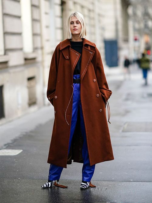 Linda Tol in einem braunen oversized Mantel und einer baggy Jeans.