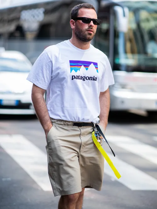 Street Style Look von der Milan Fashion Week, wo ein Gast ein Patagonia T-Shirt und eine Bermuda Short trägt.