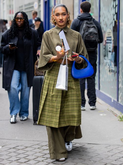 A guest is seen wearing blue bag, checkered skirt, pants, jacket outside Bianca Saunders during the Menswear Spring/Summer 2025 as part of Paris Fashion Week on June 19, 2024 in Paris, France.